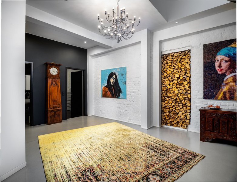 Gelb gemusterter Teppich im Flurbereich eines Wohnhauses mit auffälligen Bildern