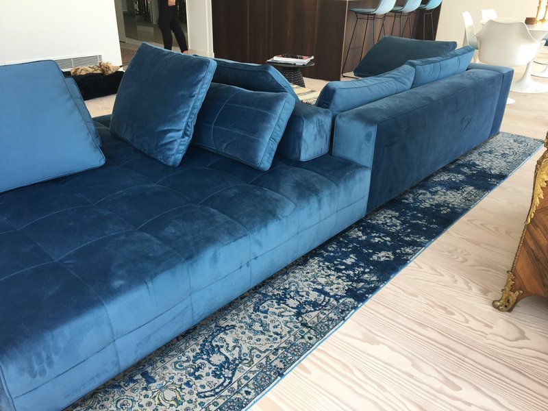 Blauer Designerteppich unter blauem Sofa, Inneneinrichtung Wohnzimmer 