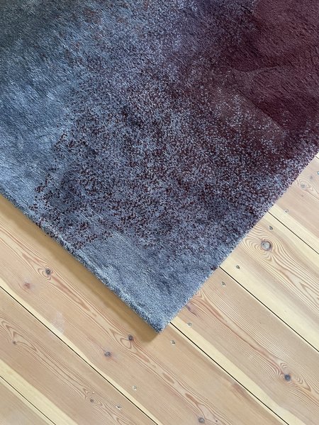 Nahansicht Details blaufarbender Teppich auf Holzboden